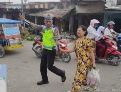 Personel Sat Lantas Dalam Situasi Padat Arus Lalu Lintas Pagi Dengan Humanis Menyeberangkan Pejalan Kaki