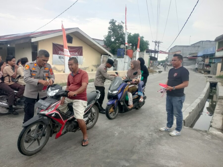 Kapolsek Medang Deras AKP AH Sagala Pasang Bendera Merah Putih 