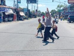 Satlantas Polres Batu Bara Bantu Pelajar Menyeberang Jalan Demi Keselamatan