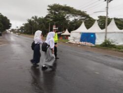 Walau Diguyur Gerimis, Satlantas Tetap Sigap Bantu Pelajar Menyebrang Jalan