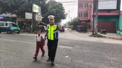 Peduli Pelajar, Kanit Gakkum Bantu Seberangkan Siswa di Jalan Raya