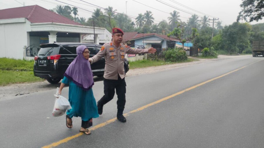 Wujud Kepedulian di Pagi Hari, Kasatresnarkoba Polres Batu Bara AKP Arifin Purba Bantu Seorang Nenek Menyeberang Jalan